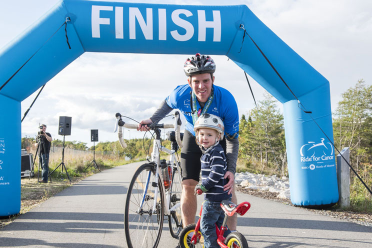 A Ride for Cancer participant hugs his son at the finish line