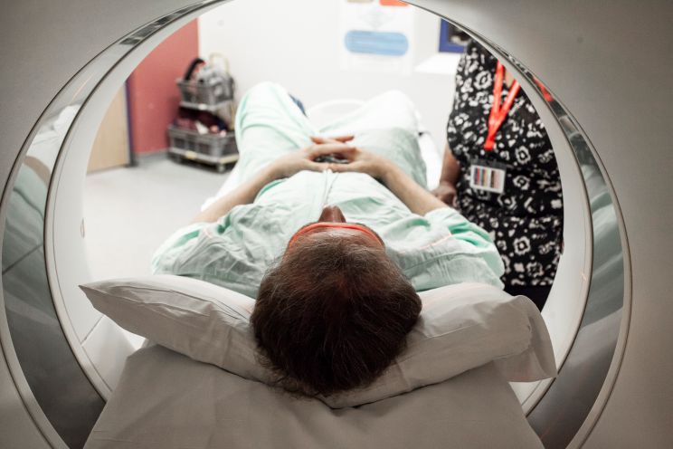 A patient undergoes a diagnostic imaging scan. He is in the scanner head first. 