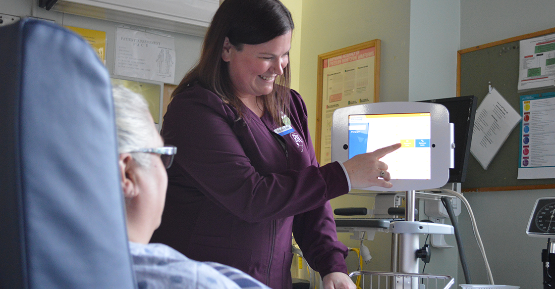 A nurse points at the Interpreter on Wheels