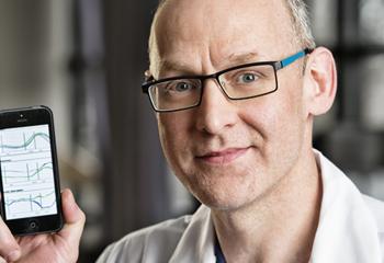 Close up of doctor with glasses holding a cell phone 