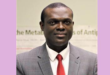 Dr. Vincent Agyapong wearing a gray suit and a red tie 