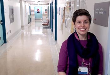Rachel Millet stands smiling in a QEII hallway