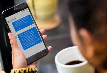 Woman holding cell phone, featuring Text4Support messages