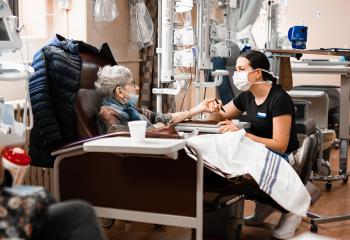 A patient and nurse sit together in the QEII