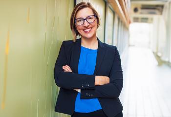 Dr. Robin Urquhart stands smiling in a hallway