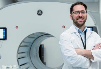 Doctor stands in front of nuclear medicine scanning technology 