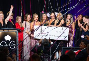 Cheque presentation photo on stage at Orchid Gala event