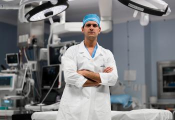 Dr Ribeiro standing in OR, with arms crossed and smiling