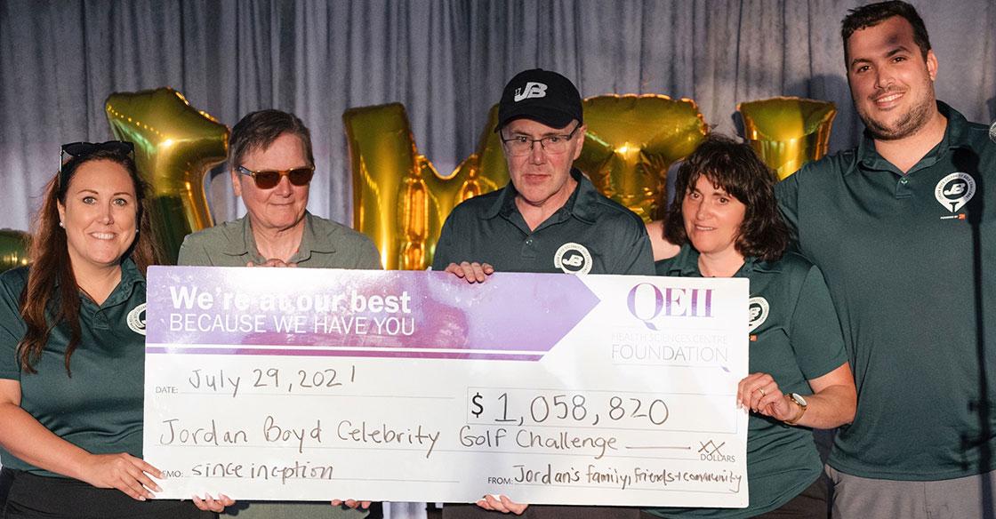 Members of the Boyd family smile with a giant cheque presented to the QEII Foundation and QEII's Inherited Heart Disease Clinic