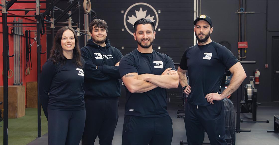 Four Blended Athletics employees dressed in black stand smiling