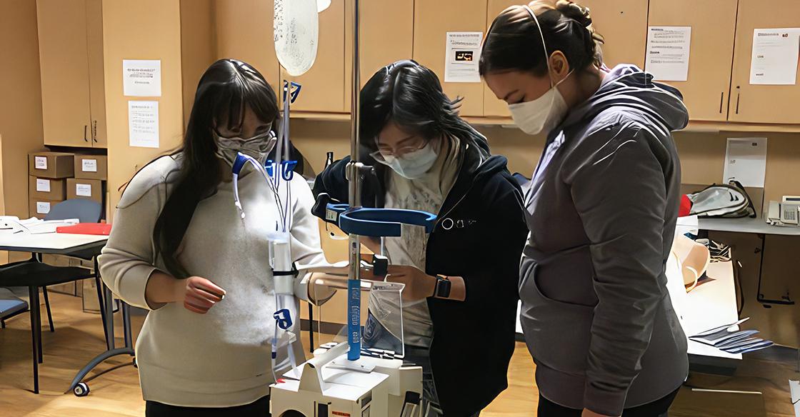 Nurses stand with the Belmont Rapid Infuser
