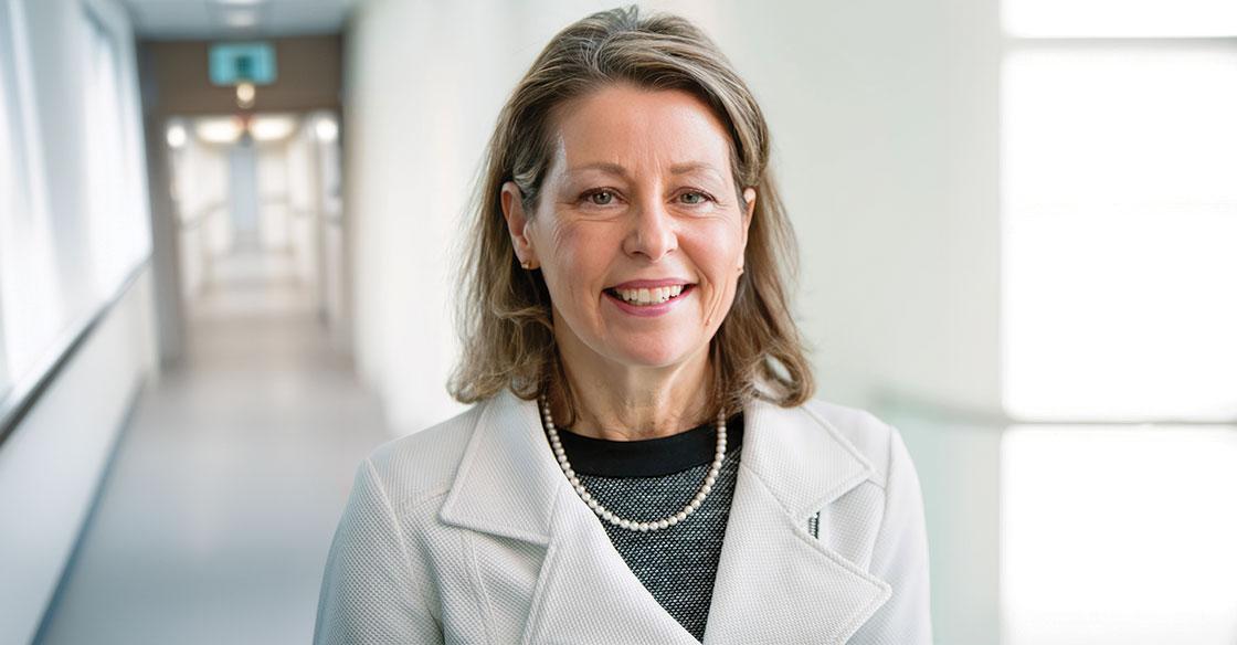 Dr, Sharon Mulvagh wearing a white blazer in a medical hallway
