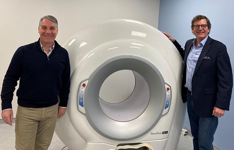 Two QEII physicians stand in front of the new cone beam CT scanner.