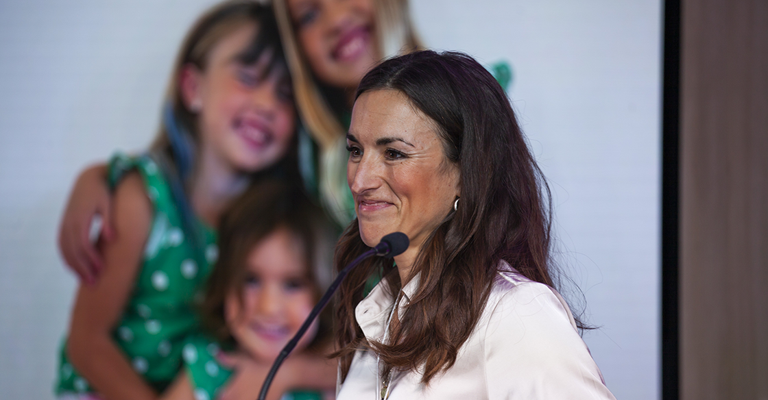 Dr. Jennifer Johnston stands at the podium, making her Better Ring pitch at Innovation Den 2023.