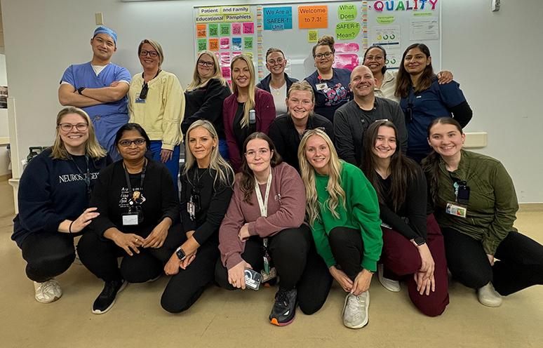 A group of QEII neurosurgery and spine surgery healthcare workers pose for the camera.
