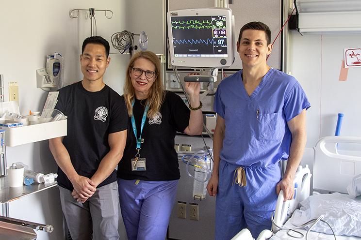 QEII Burn Unit staff stand in a patient room, displaying the new IMCU monitor.