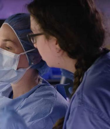 Two lab technicians prepare doses at the cancer clinic