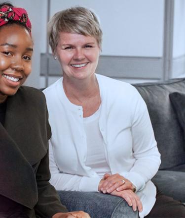 Two mental health support staff are sitting on a couch