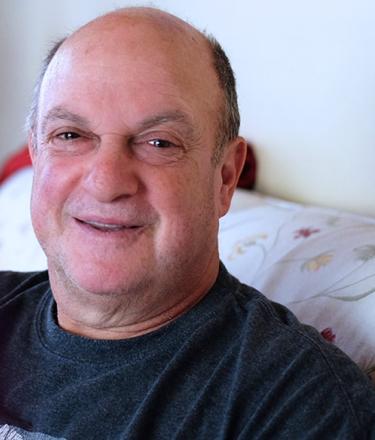 Lorne Abramson, a QEII patient is sitting in his living room.