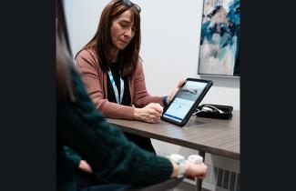 An occupational therapist assesses a patient's progress using new technology.