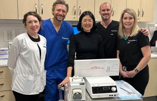 A healthcare team poses with the new thyroid procedure equipment.