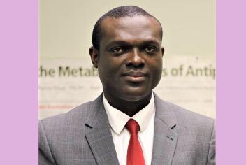 Dr. Vincent Agyapong wearing a gray suit and a red tie 