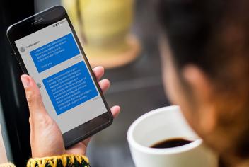 Woman holding cell phone, featuring Text4Support messages