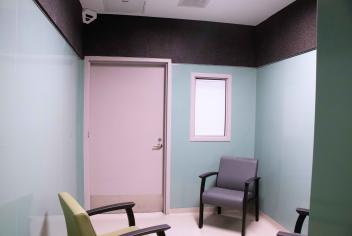 Picture of the Psychiatric Emergency Care Suites; a bright room with blue walls and comfy, weighted chairs