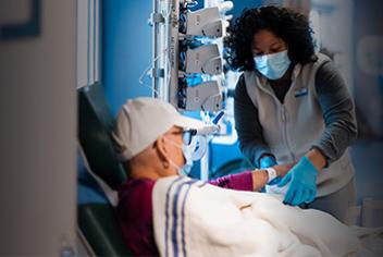 female healthcare worker and a male patient wearing a cap