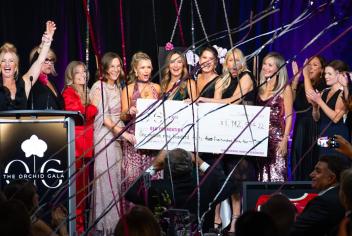 Cheque presentation photo on stage at Orchid Gala event